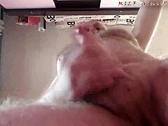 Ein Mann mittleren Alters erfreut einen jungen Webcam-Zuschauer, indem er vor der Kamera masturbiert