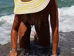 Zralá žena s roztaženými piercingy na bradavkách a několika piercingy v kundičce na pláži