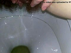 Amatør MILF får et nærbillede af hendes våde klitoris og fingre på toilettet