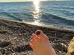 La señora Lara adora los pies y juega con los dedos de los pies en la playa