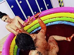Lesbiske med store falske bryster nyter å bryte i en basseng med gelé
